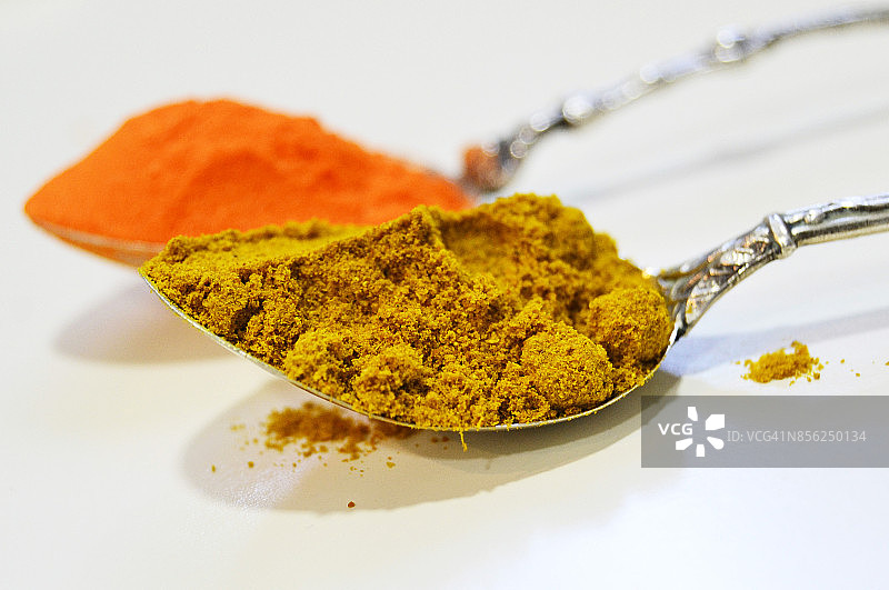 银色茶匙中的咖喱和藏红花粉图片素材