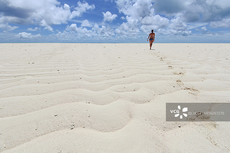 女人走在帕劳卡扬杰环礁的白色沙滩上图片素材