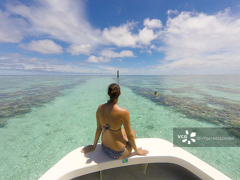 女孩坐在船头，驶向卡扬杰环礁图片素材