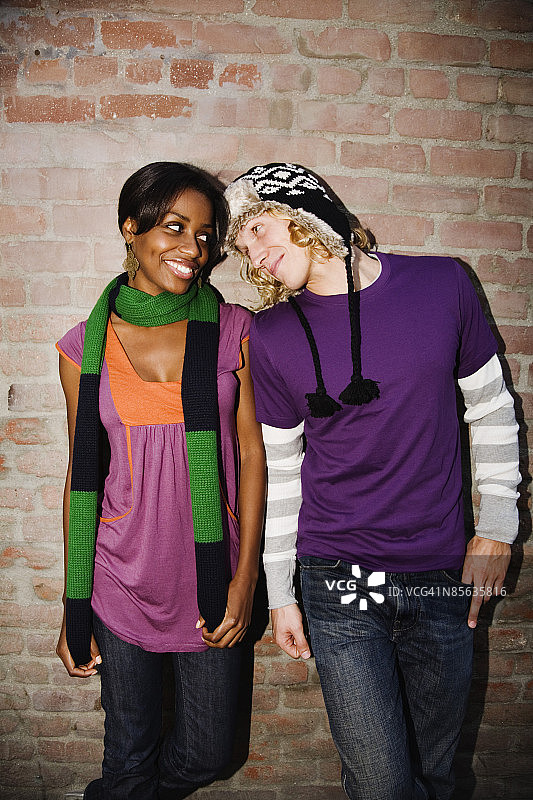 情侣站在砖墙旁图片素材