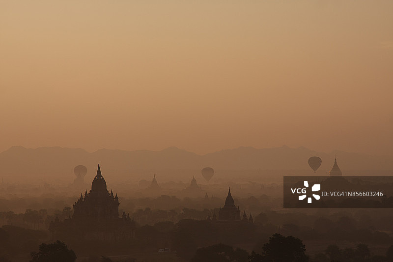 缅甸曼德勒蒲甘平原雾气中飞行的热气球美景图片素材