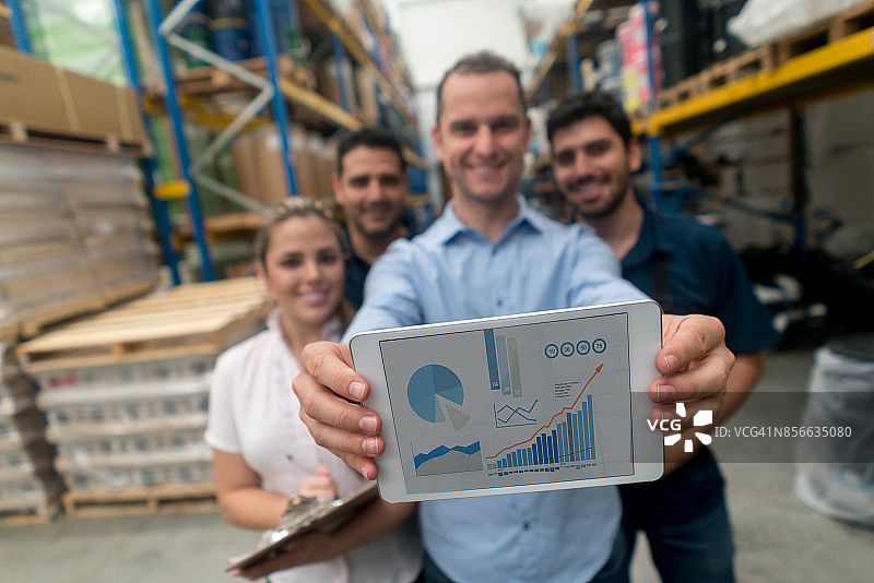 在仓库工作的工人展示增长图图片素材