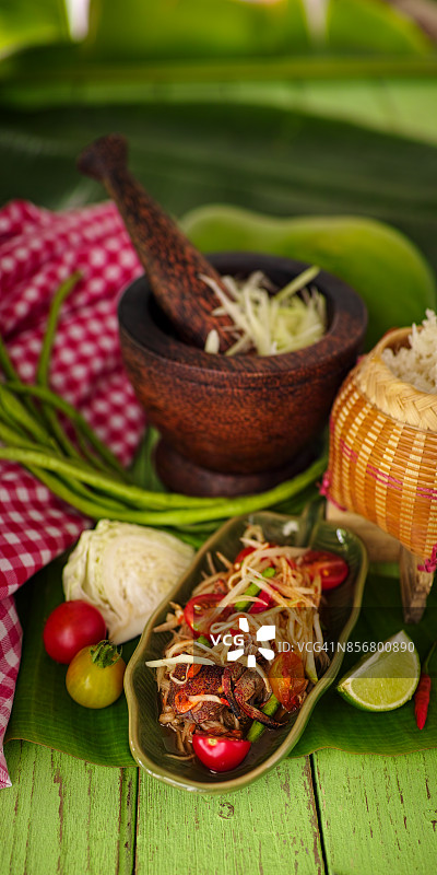 泰式青木瓜沙拉：鲜嫩的木瓜丝、淡水蟹、辣椒、番茄、棕榈糖和虾米与糯米饭的美味组合图片素材