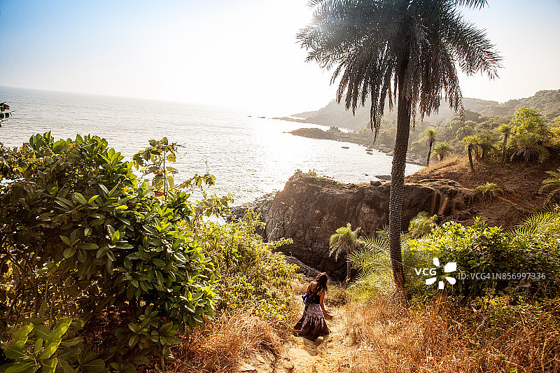 年轻女人走在印度南部戈卡纳海岸附近的小路上图片素材