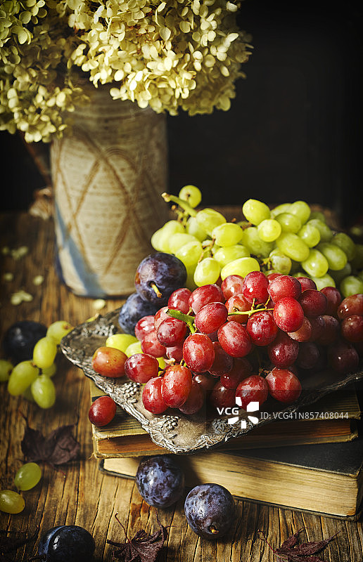 金属托盘上的新鲜葡萄和李子图片素材
