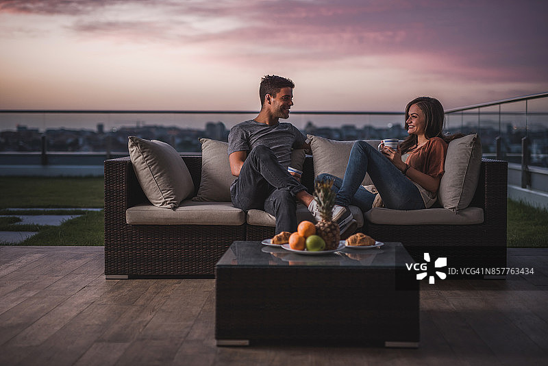 情侣在黄昏的露台上放松交流图片素材