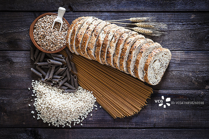 乡村木桌上的全麦面包、意面和米饭图片素材