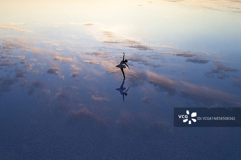 在傍晚湖面上跳舞的年轻芭蕾舞女演员图片素材
