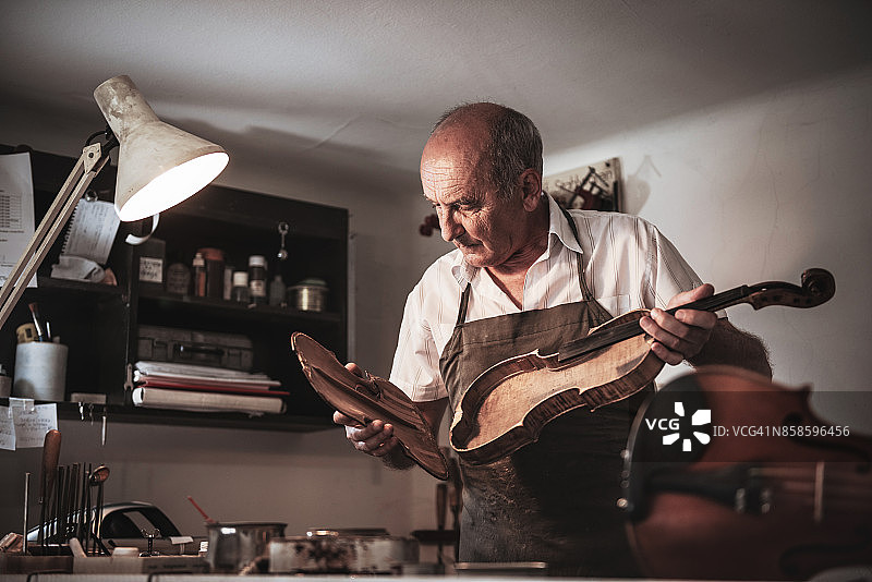 年长的工匠有能力修理弦乐器图片素材