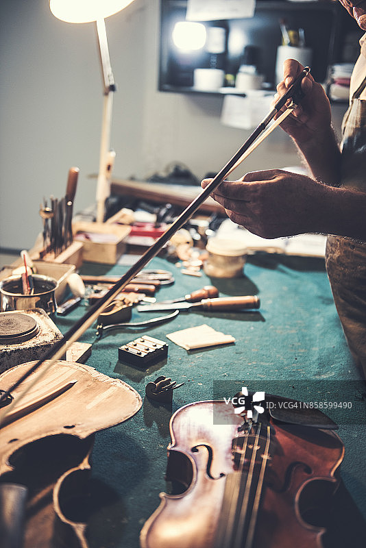 维修人员检查小提琴的琴弓图片素材