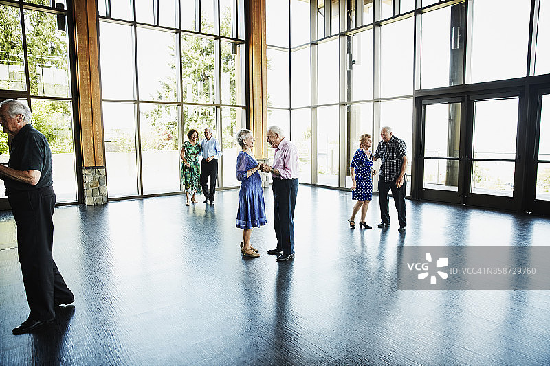 老年夫妇在社区中心跳舞后手牵手，笑容满面图片素材