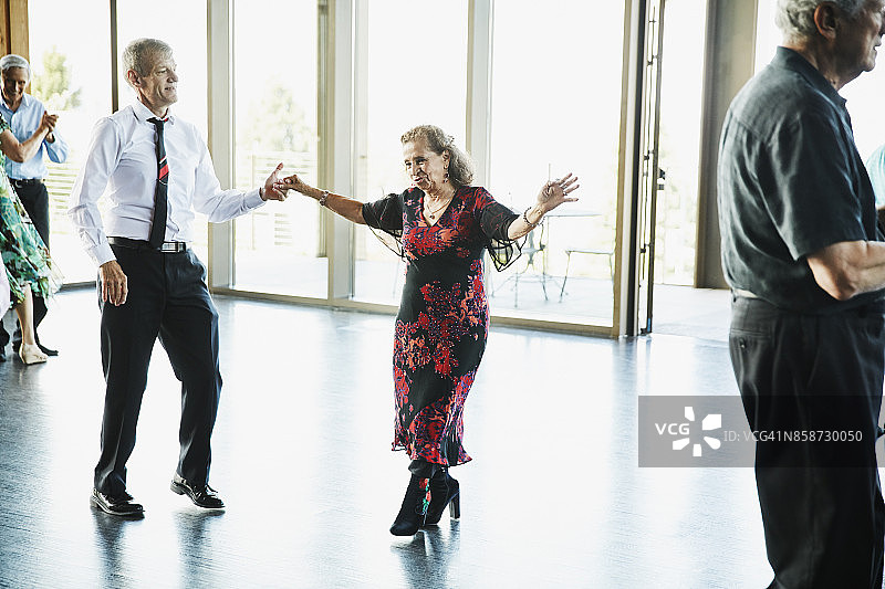 在社区中心与舞伴跳舞的老年妇女图片素材