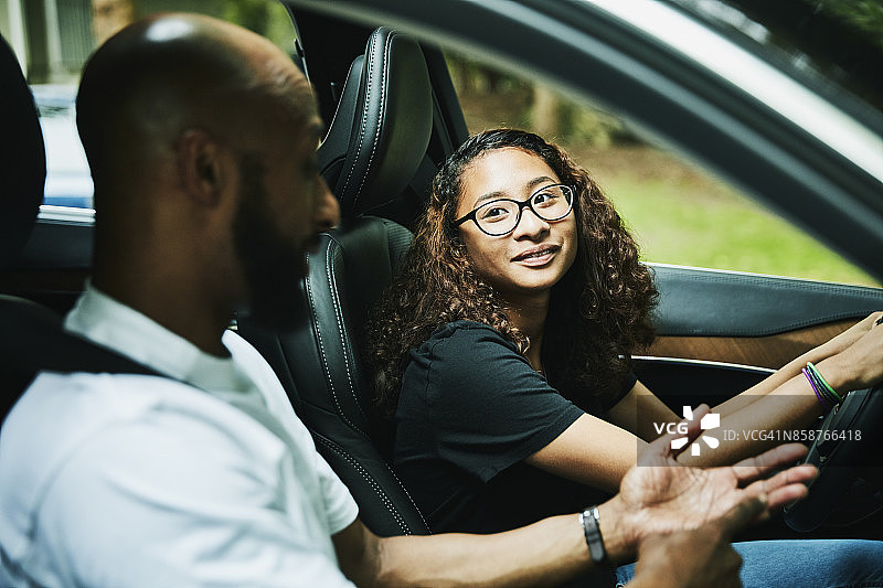 年轻女子在驾驶座上听取建议图片素材