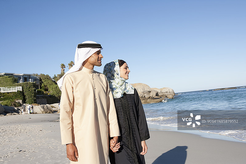 阿拉伯夫妇在海滩上手牵手图片素材