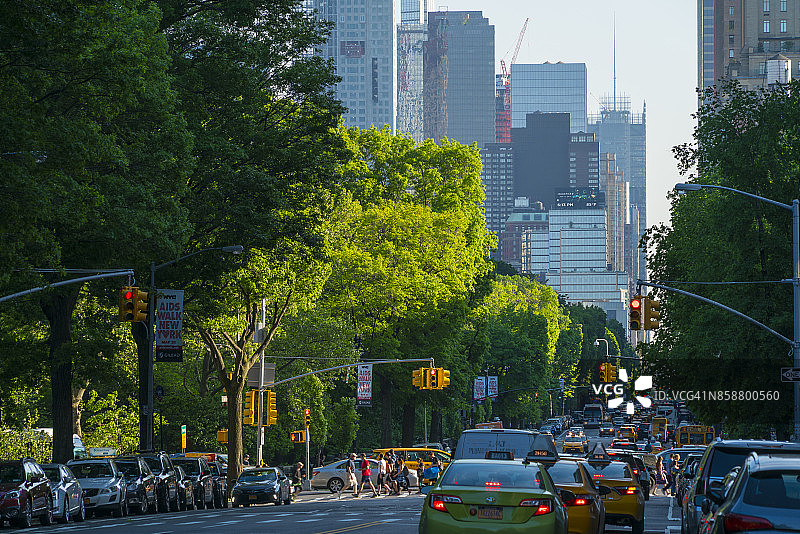 傍晚时分纽约中央公园西侧第八大道的交通，背景是曼哈顿中城的摩天大楼图片素材