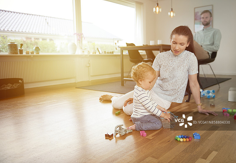 妈妈和孩子和狗在地板上玩耍图片素材