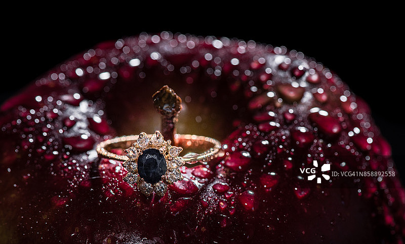 带水滴和黑色背景的红绿苹果上的戒指图片素材