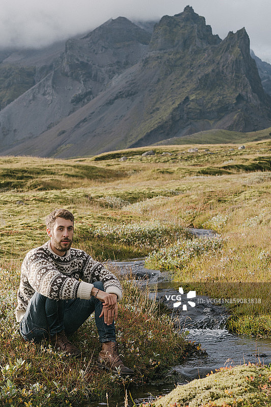 坐在河边欣赏冰川的男人图片素材