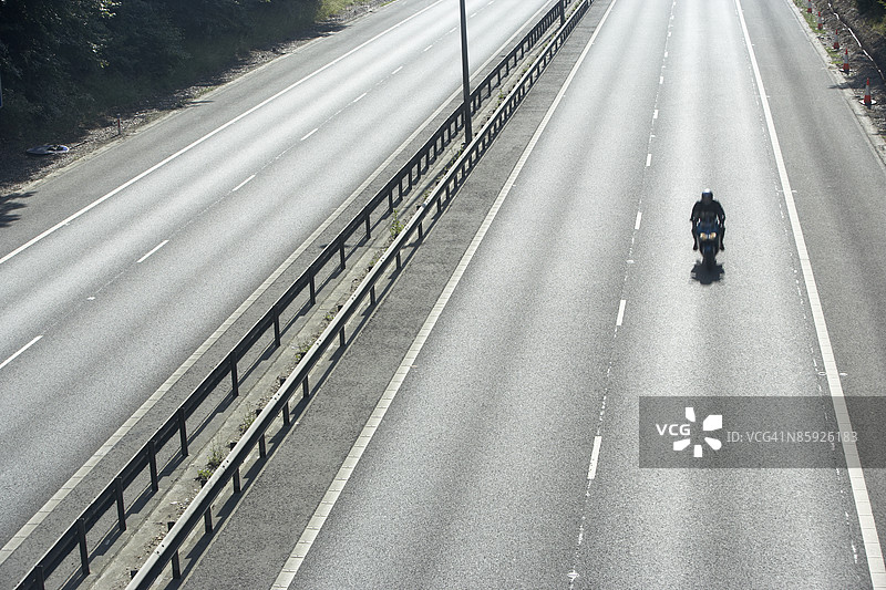 孤独骑士在空旷的高速公路上图片素材