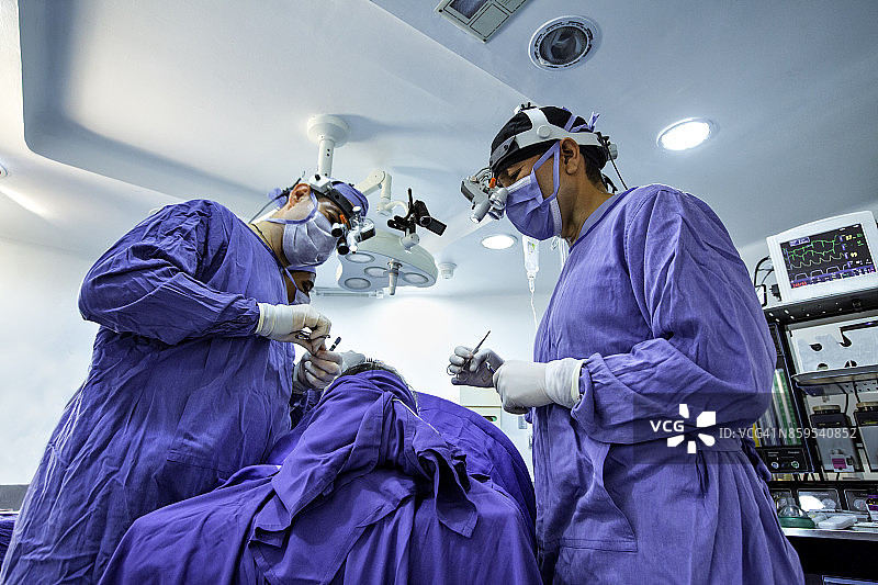 外科医生为女性患者进行肋软骨切取术，治疗鼻中隔偏曲和隆鼻手术图片素材