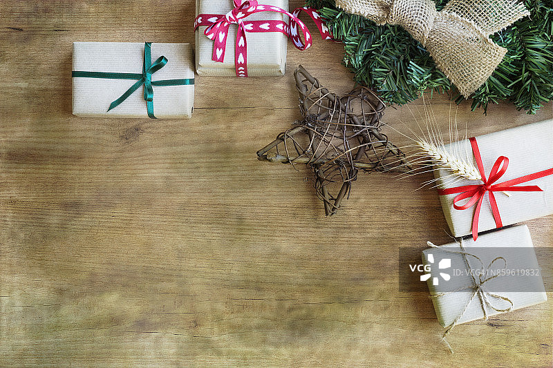 用乡村纸和彩色丝带包裹的礼品盒，木质背景图片素材