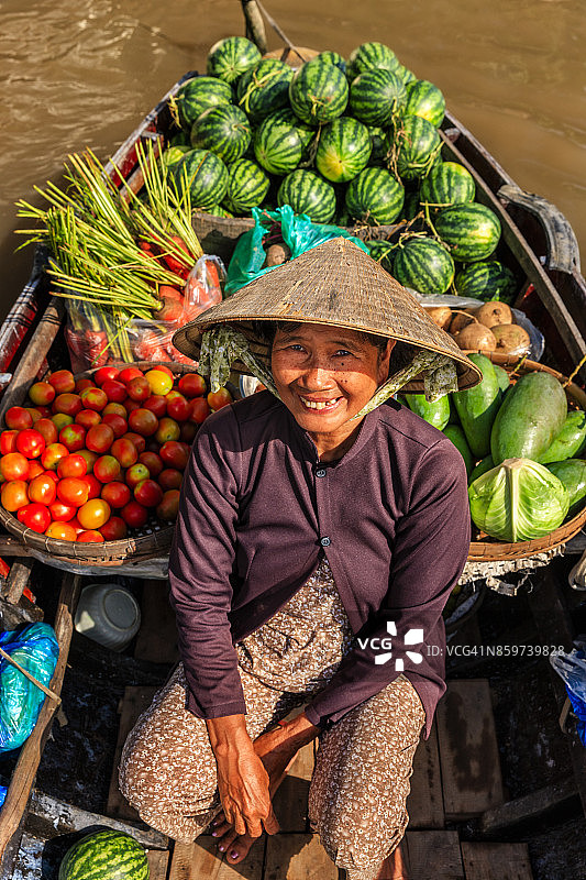 在越南湄公河三角洲水上市场卖水果的越南妇女图片素材