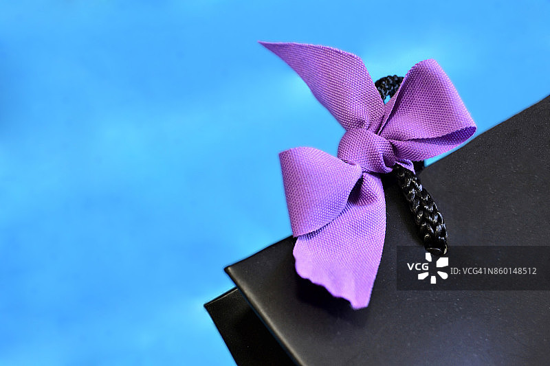 系着紫色蝴蝶结的黑色礼品袋图片素材