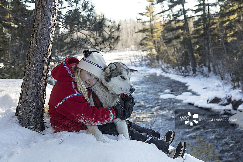 年轻女孩和哈士奇雪橇犬图片素材