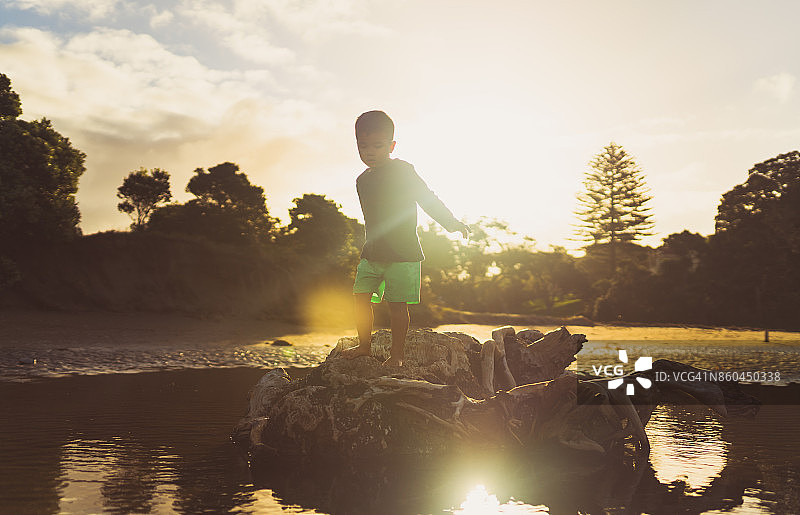 在原木上行走，背景是日落图片素材