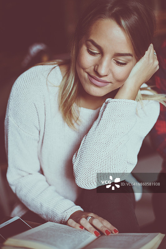 在家读书的年轻微笑女学生图片素材