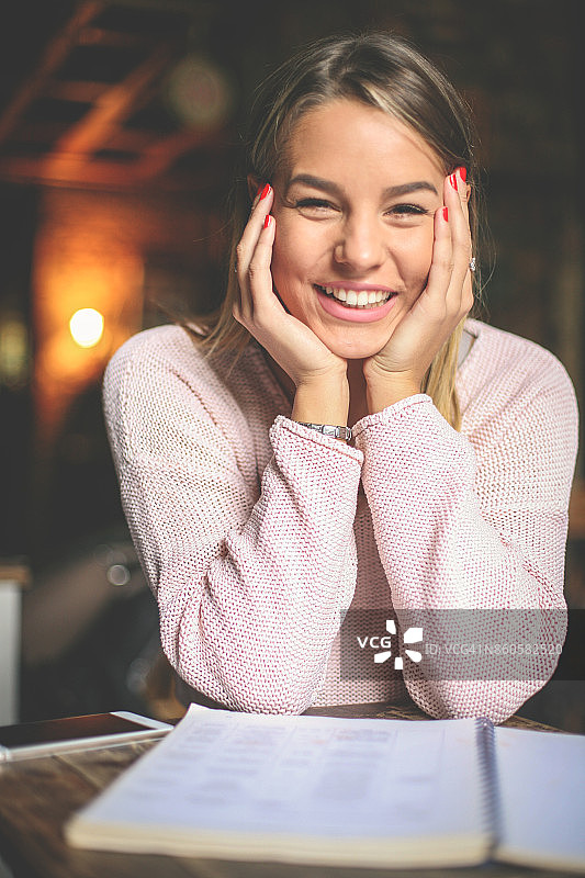 快乐的女学生在学习并看着镜头图片素材