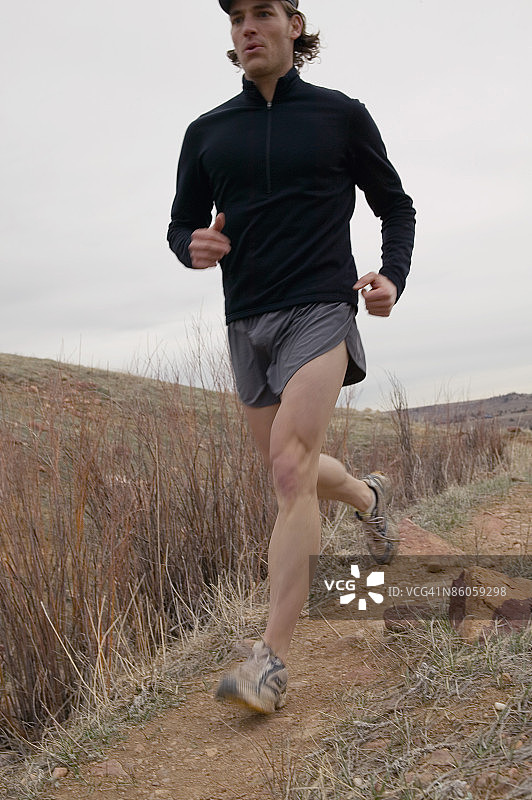 在泥泞小路上慢跑的男人图片素材