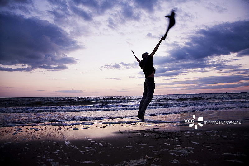 男人在海滩上跳跃图片素材