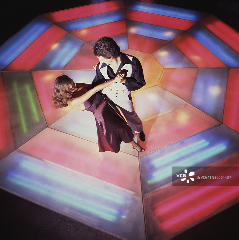 情侣在彩色舞池中跳迪斯科图片素材