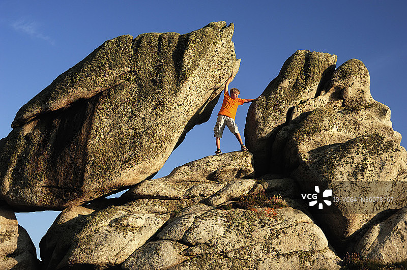 站在巨石之间的男孩图片素材