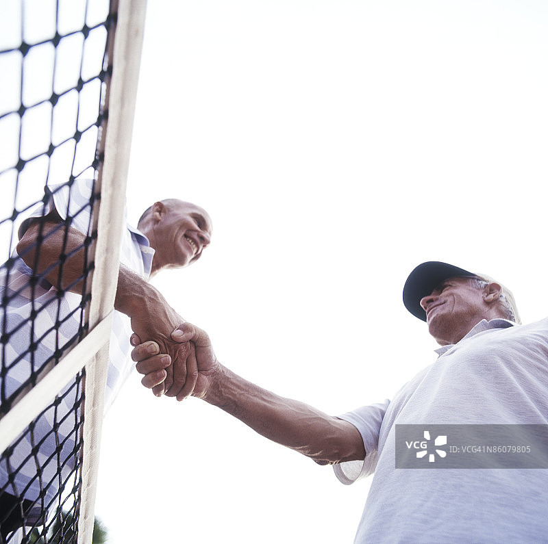 男人在网球网前握手图片素材