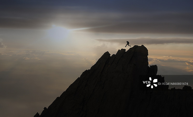 攀岩者在岩脊上跳跃图片素材