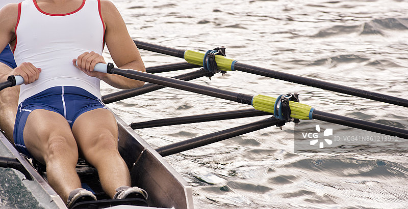 在傍晚划船穿过湖面的男运动员图片素材