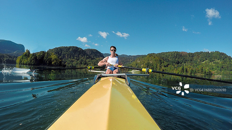 阳光下划黄色无舵双人艇的男运动员图片素材