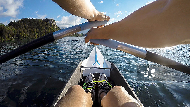 运动员在阳光明媚的湖上划船图片素材