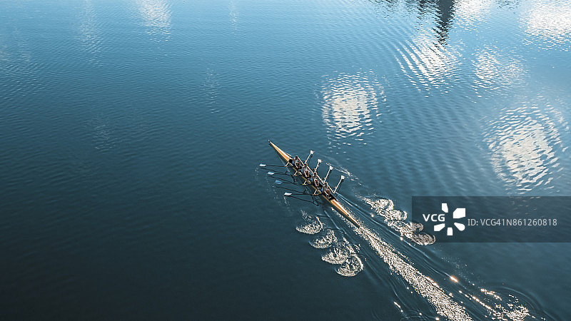 阳光下，四名男运动员在湖上划船图片素材