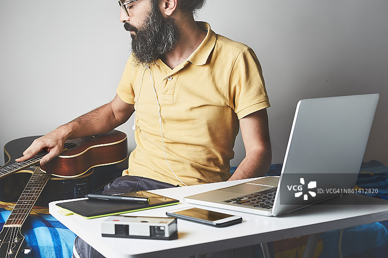 男子在房间里录音并弹奏尤克里里图片素材