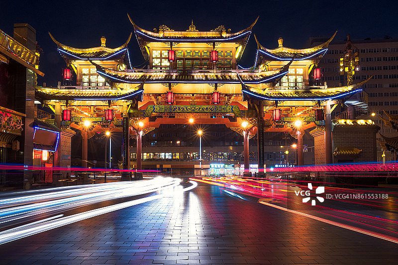 夜晚亮灯的秦台路中式传统大门与车辆图片素材