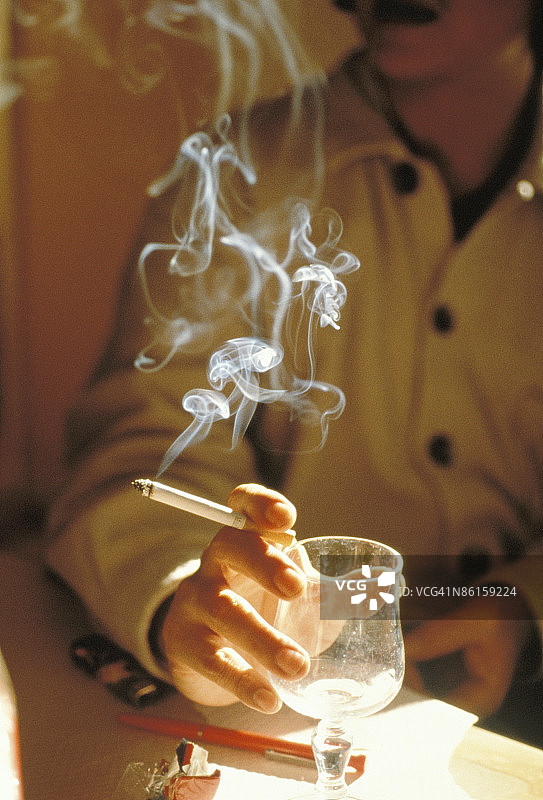 男子拿着香烟和空玻璃杯图片素材