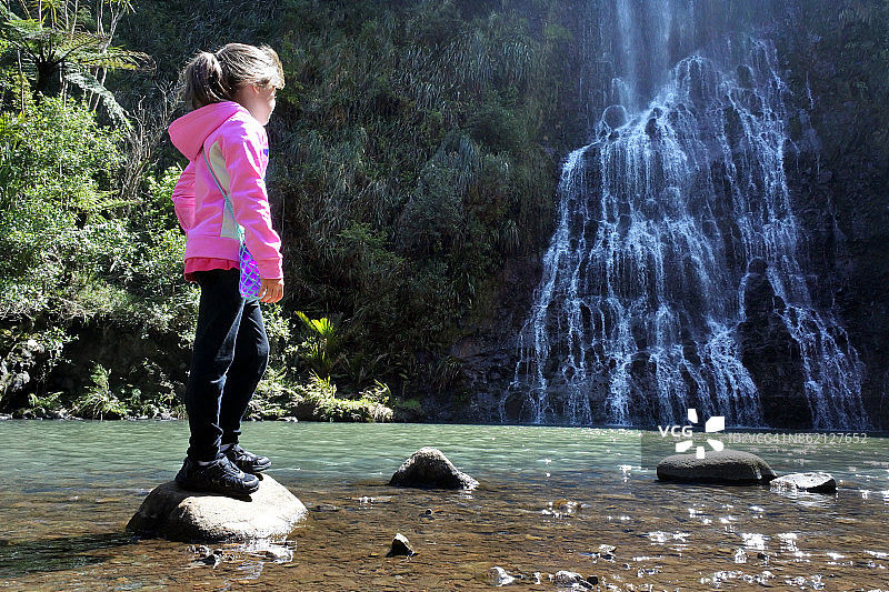 年轻女孩在新西兰瀑布前图片素材