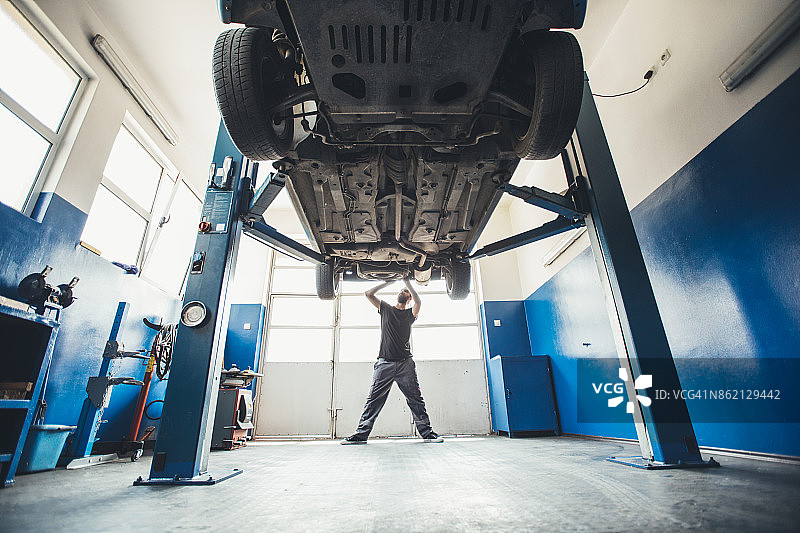 在室内修理汽车的汽修工图片素材