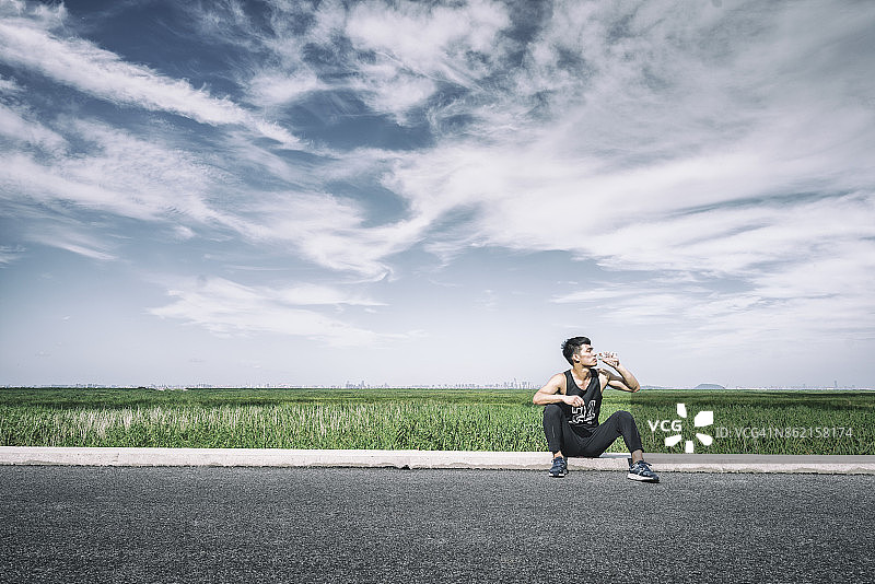 亚洲跑步者运动后饮水图片素材