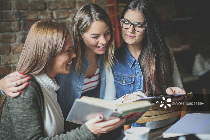 在咖啡馆一起学习的三个女学生图片素材