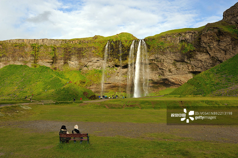 两人坐在冰岛南部塞里雅兰瀑布前图片素材