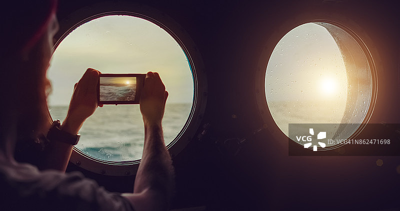 在波涛汹涌的大海上，船只舷窗旁的男人图片素材